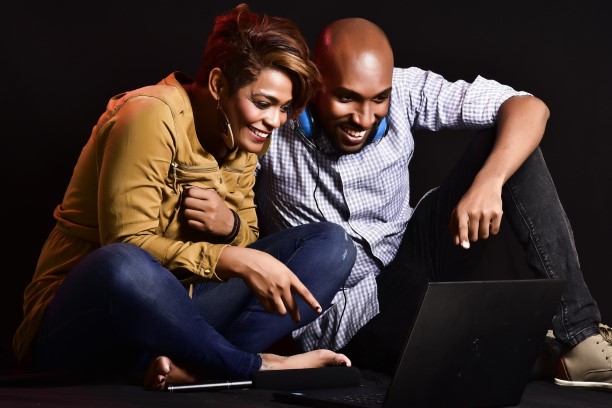 black man and woman looking at the laptop.